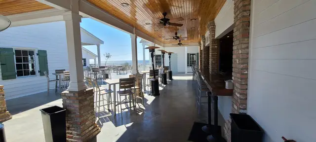 The oyster bar walkway with brick columns, cypress ceiling and a view of Lake Pontchartrain