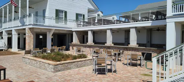 The brick courtyard with planter, tables and the deck overhead