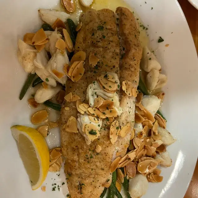 Gulf fish almondine with crabmeat and toasted almonds, seen from above