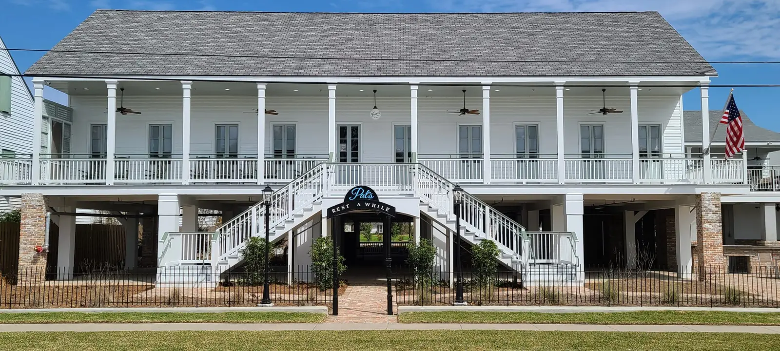 The white two-story Frapart Hotel facade with its double staircase and the Pat's Rest Awhile entry arch