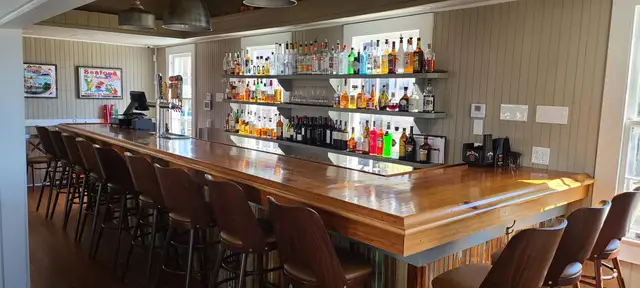 The Sophie Tavern bar with backlit bottles and a warm wood countertop
