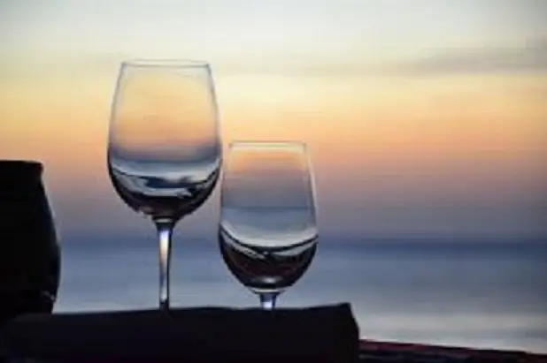 Wine glasses at sunset over the water